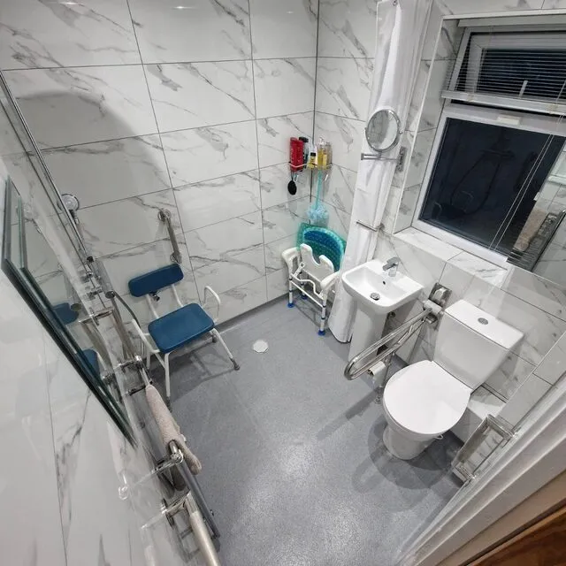 Accessible wet room with grab rails and a fold-down shower seat