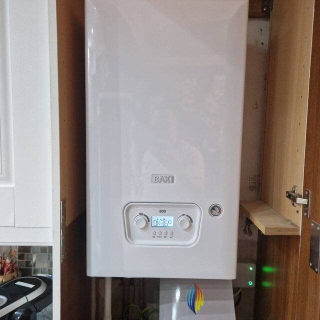 Baxi combi boiler installed inside a kitchen cupboard, handed over with a full boiler paperwork pack from Downs Plumbing & Heating