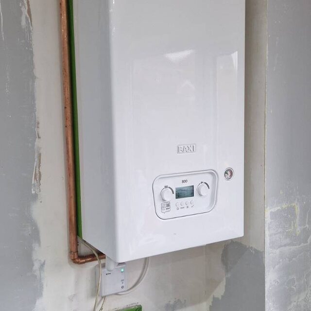 New Baxi combi boiler installed in a hallway cupboard with fresh copper pipework and a new flue, fitted by a Gas Safe registered engineer at Downs Plumbing & Heating