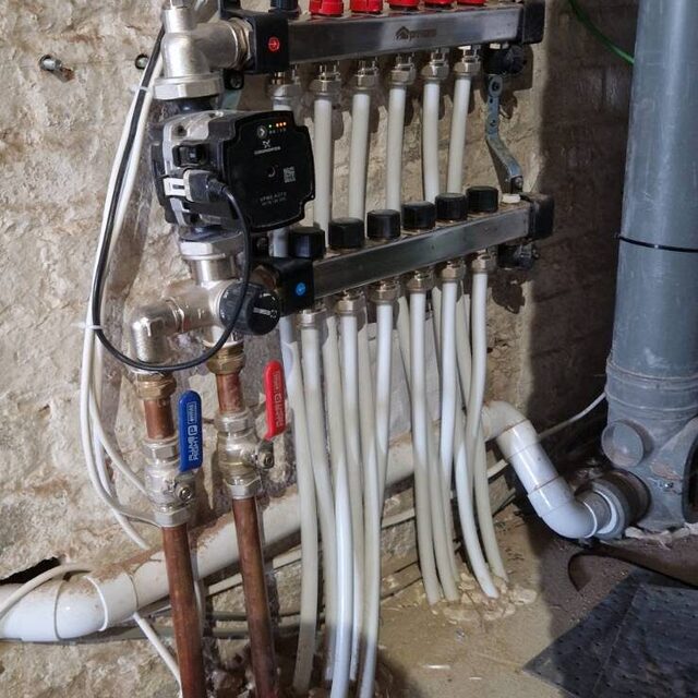 Underfloor heating manifold with circulating pump, blending valve and individually balanced pipe loops, installed by Downs Plumbing & Heating in Kent